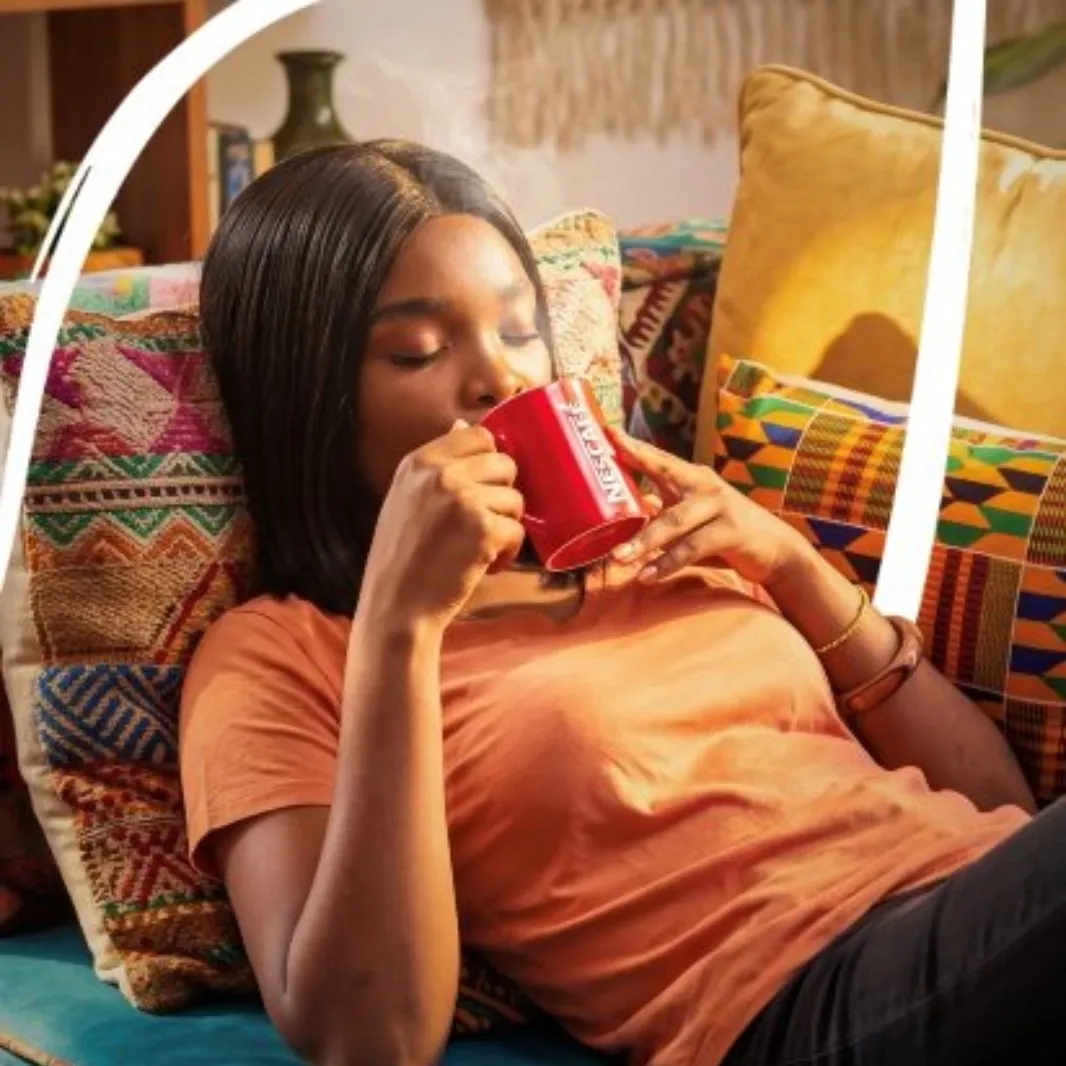 se relaxant dans un canapé tout en dégustant une recette de café