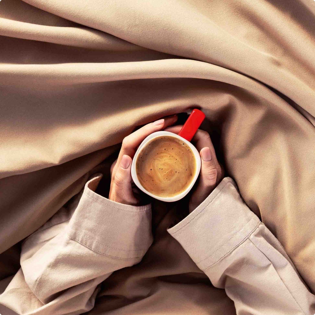 ruce držící červený hrnek nescafé