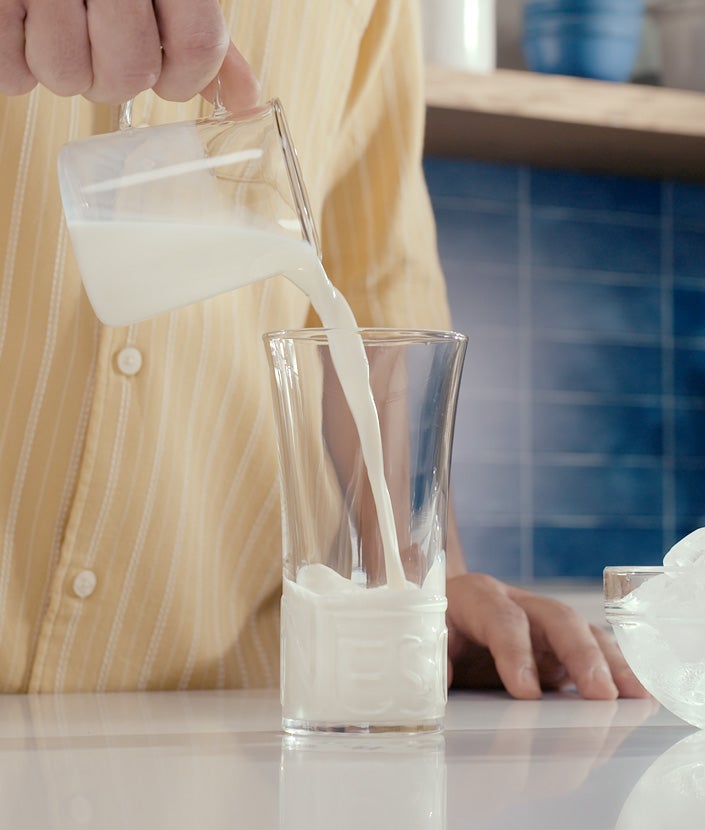 Mann gießt Wasser in Glas