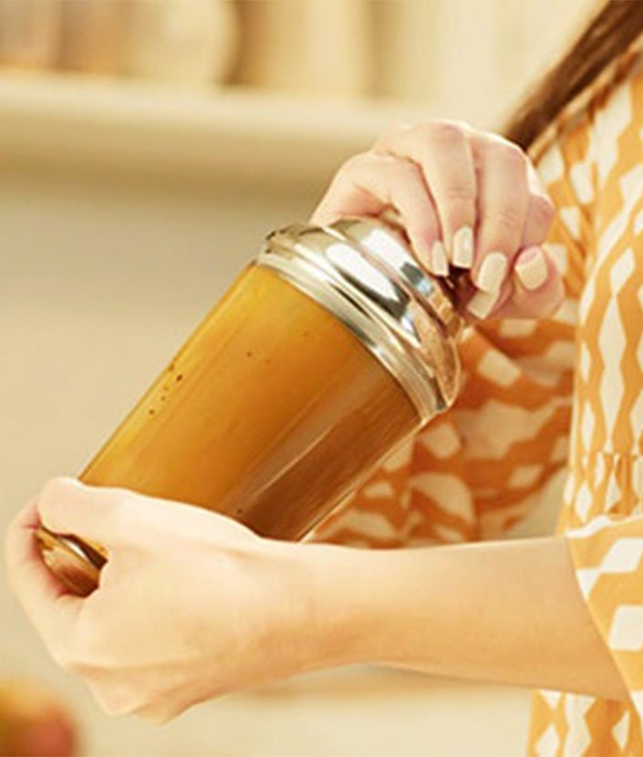 Kvinde som shaker en NESCAFÉ Mango Frappé