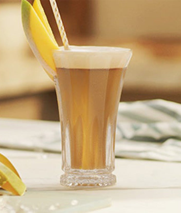 Glas indeholdende en NESCAFÉ Mango Frappé