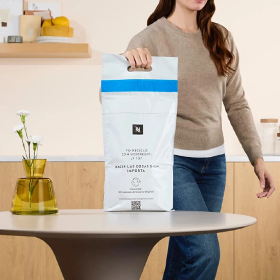 Persona sosteniendo una bolsa de reciclaje de cápsulas Nespresso®