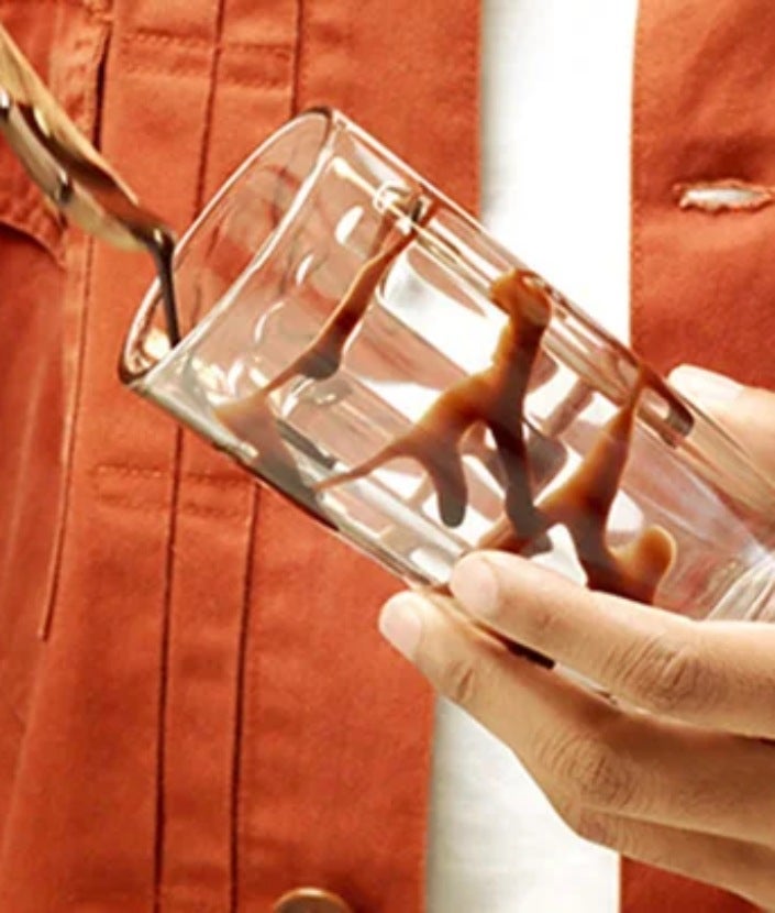 Homme décorant un verre du coulis de chocolat