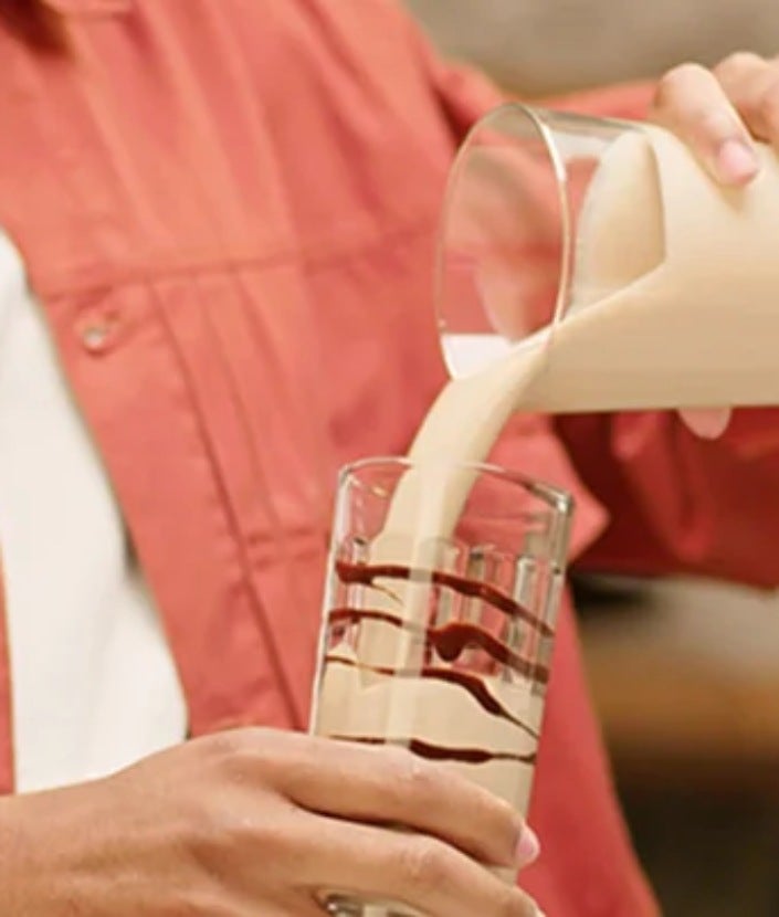 Homme versant le NESCAFÉ Frappé Cappuccino Mocha dans un verre