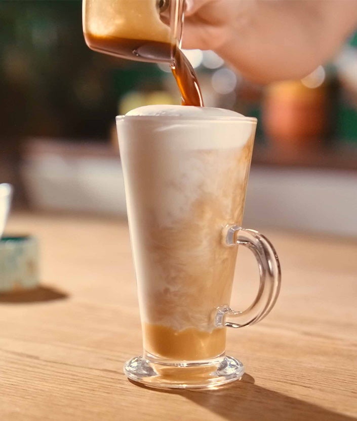 Verser un shot de café dans un verre de latte