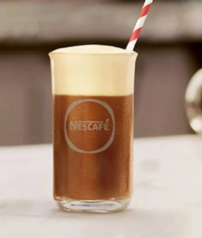 Verre contenant un NESCAFÉ Frappé Latte instantané