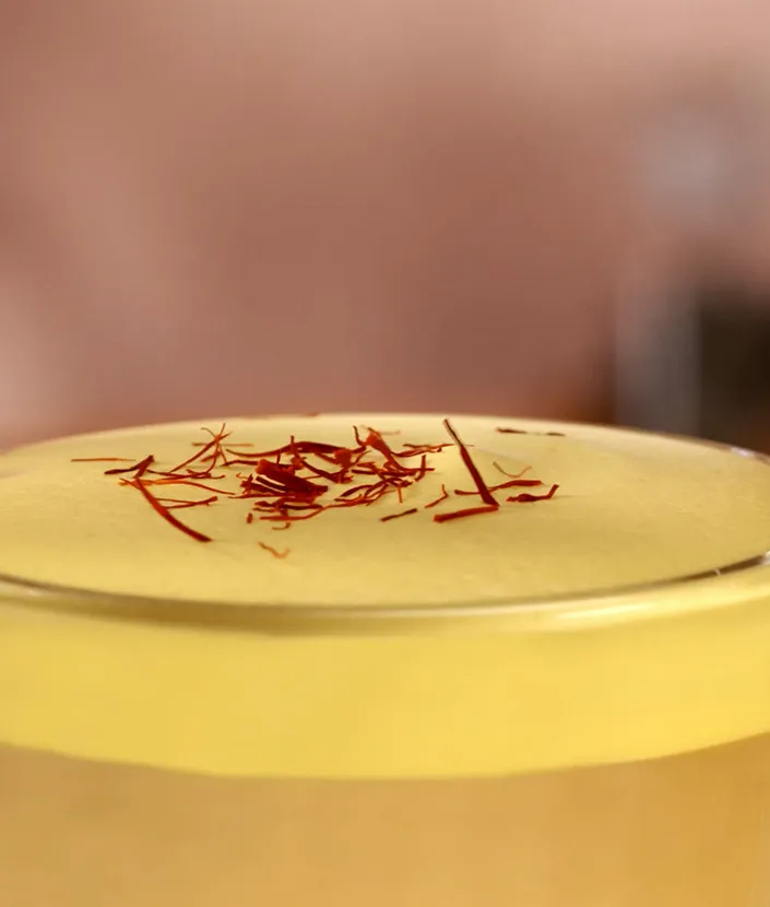 Latte au safran décoré de quelques filaments de safran sur la mousse de lait