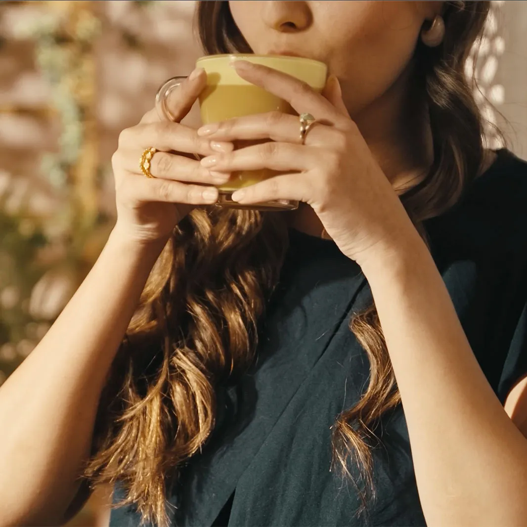 Femme en train de boire un latte au safran