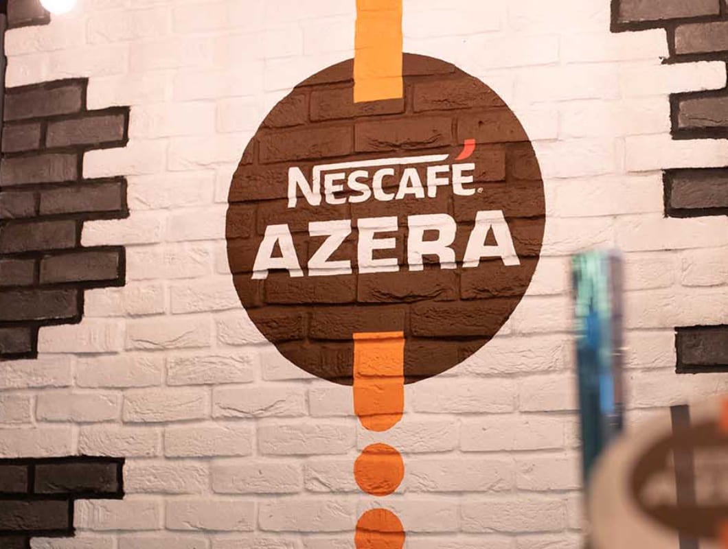 Nescafé Azera logo on a brick wall