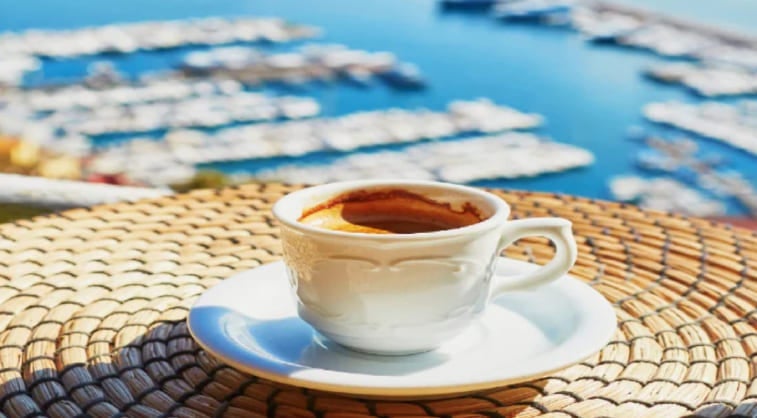 A cup of Italian coffee on a table overlooking a marina