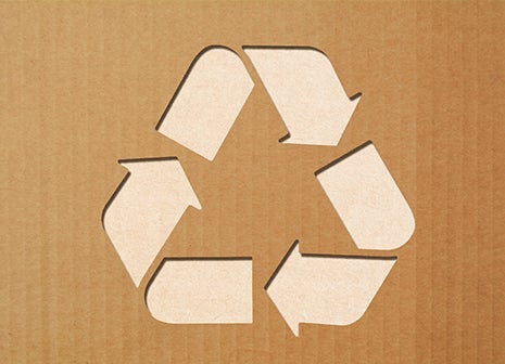 Cardboard with a recycling symbol cut out from it