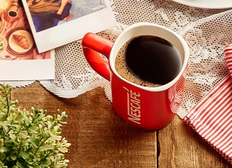A mug of Nescafé coffee on a wooden table