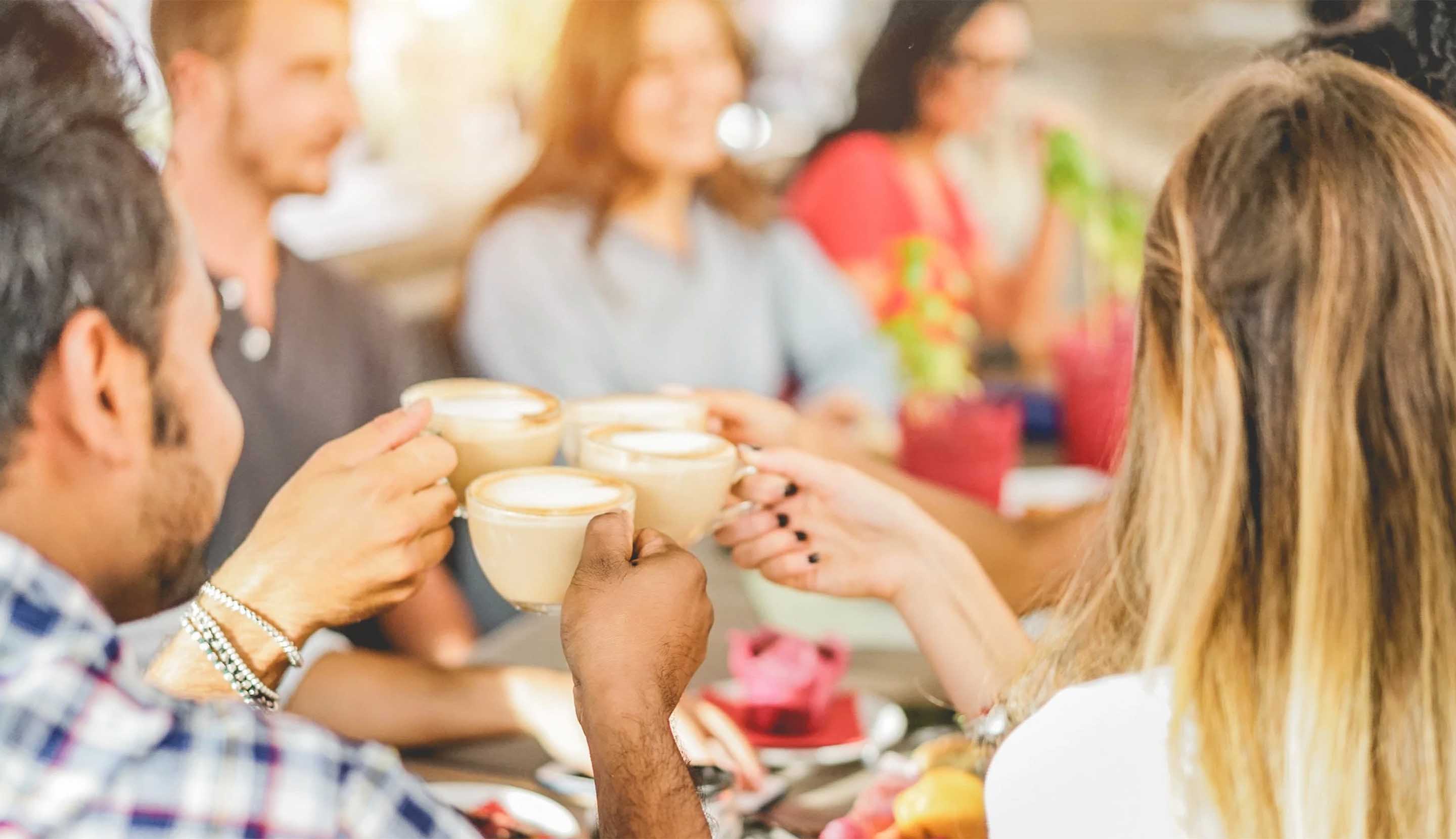 Four people celebrating with a coffee each