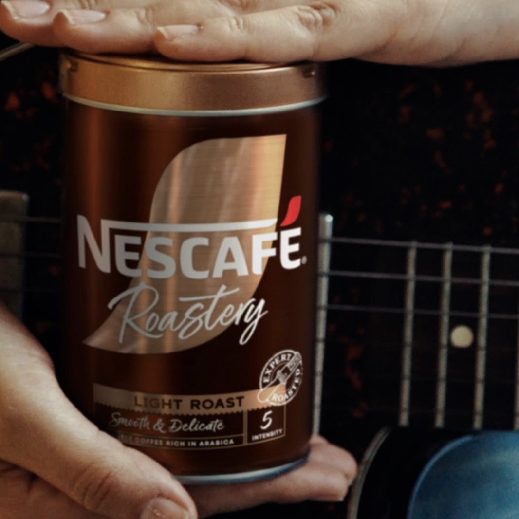 hands holding a tin of nescafe roastery