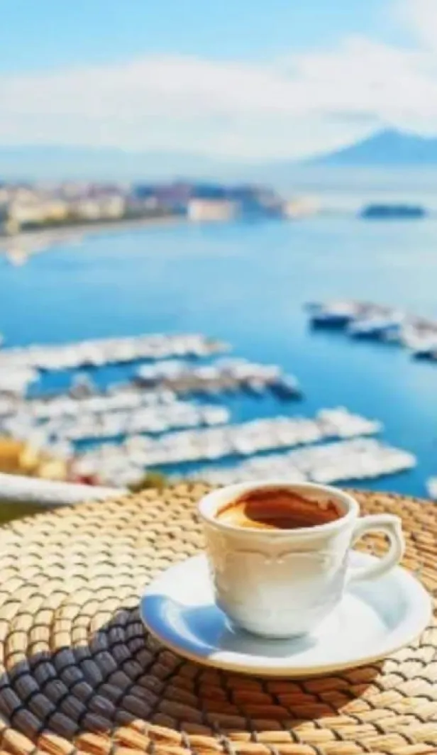 A cup of Italian coffee on a table overlooking a marina