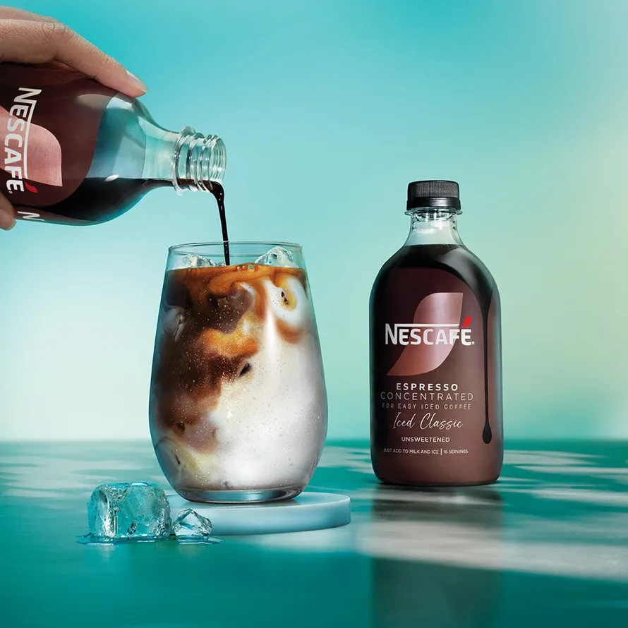 hand pouring coffee in glas