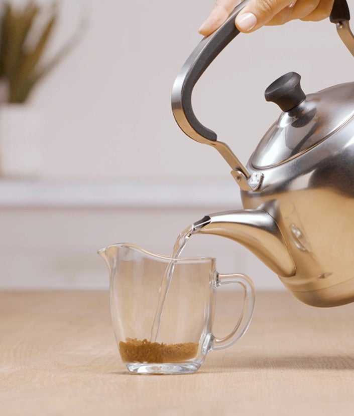 Ulijevanje vruće vode u vrč s Nescafé Classic kavom