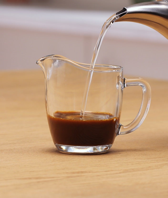 Ulijevanje vruće vode u vrč s Nescafé Classic kavom