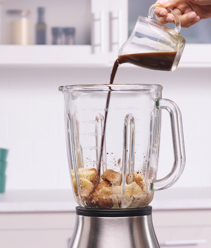 Ulijevanje mješavine vode i kave u blender s raznim sastojcima
