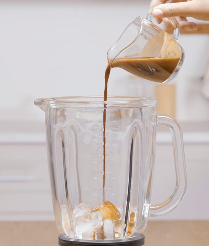 Dodavanje mješavine kave i vode u blender s kockicama leda