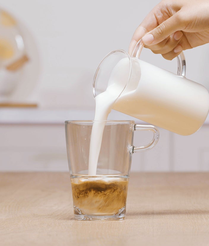 Dodavanje zapjenjenog mlijeka u mješavinu kave i vode