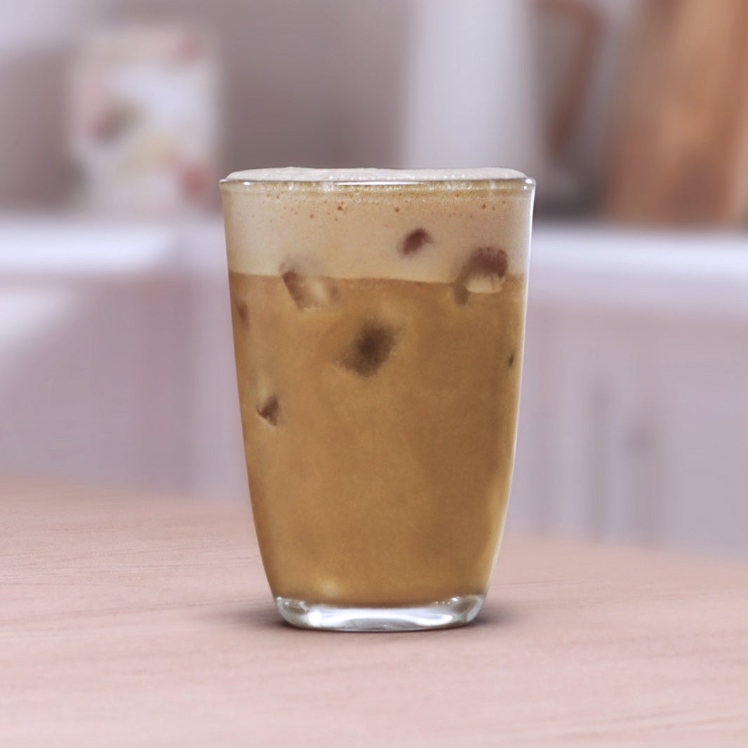 Iced Coconut Latte u staklenoj čašiPrelijevanje vode u stakleni vrč s kavom