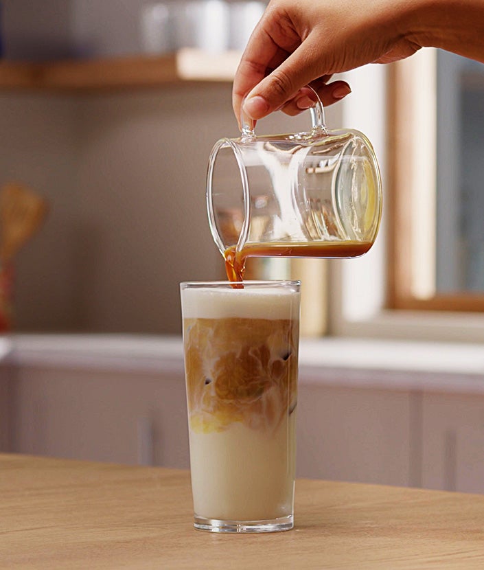 Dodavanje mješavine kave u čašu s mlijekom i ledom