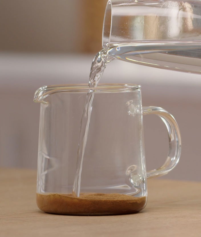 Ulijevanje vruće vode u vrč s kavom