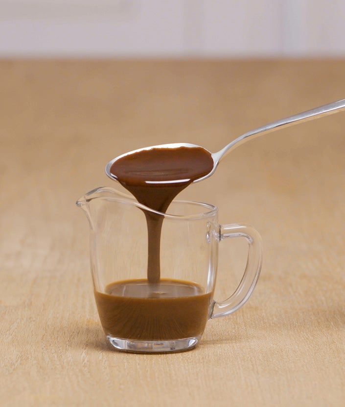 Dodavanje žlice čokoladnog sirupa u vrč za kavu