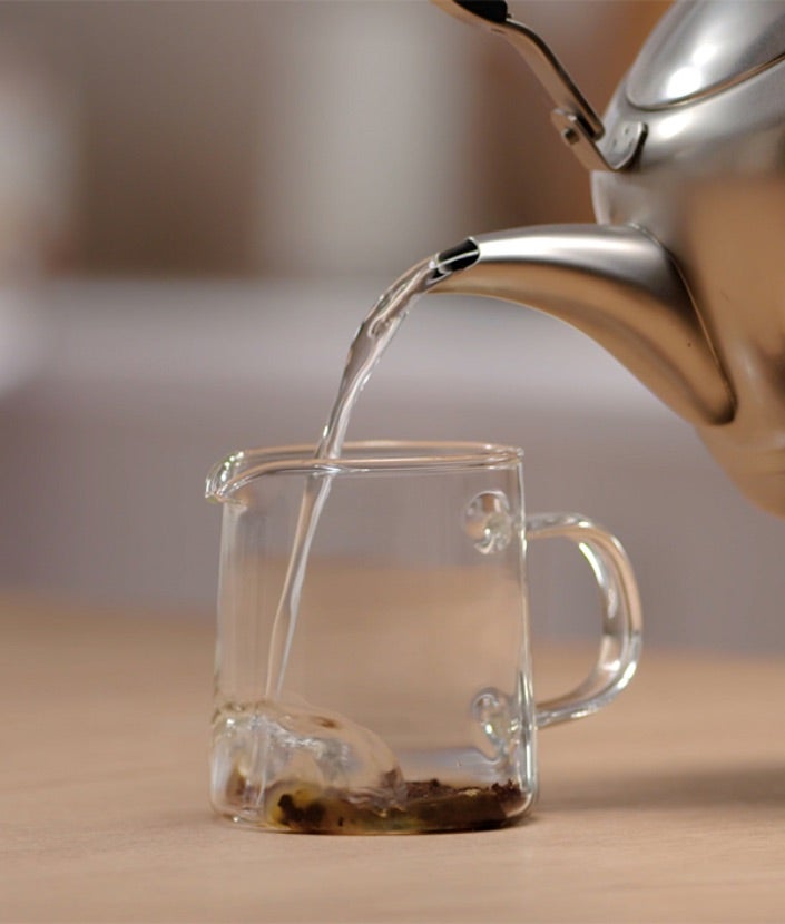 Prelijevanje vode u stakleni vrč s kavomIced Coffee step 1