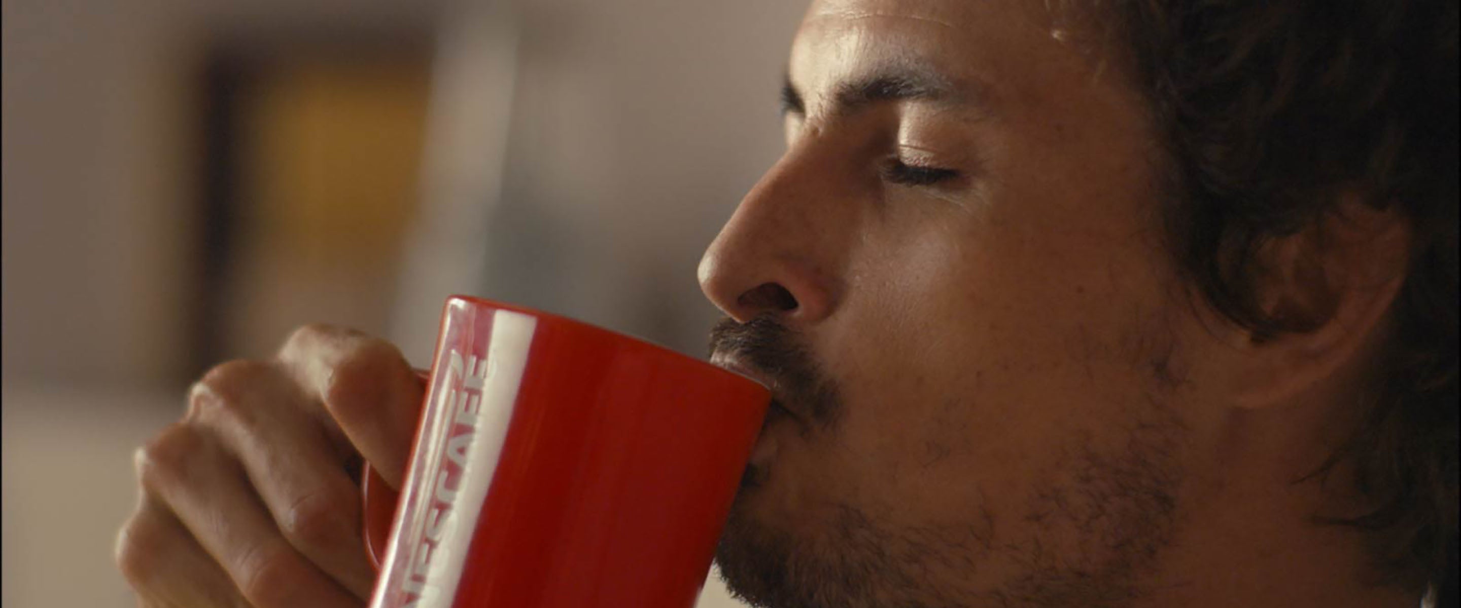 Muškarac uživa u kavi NESCAFÉ Classic s crvenom šalicom u ruci