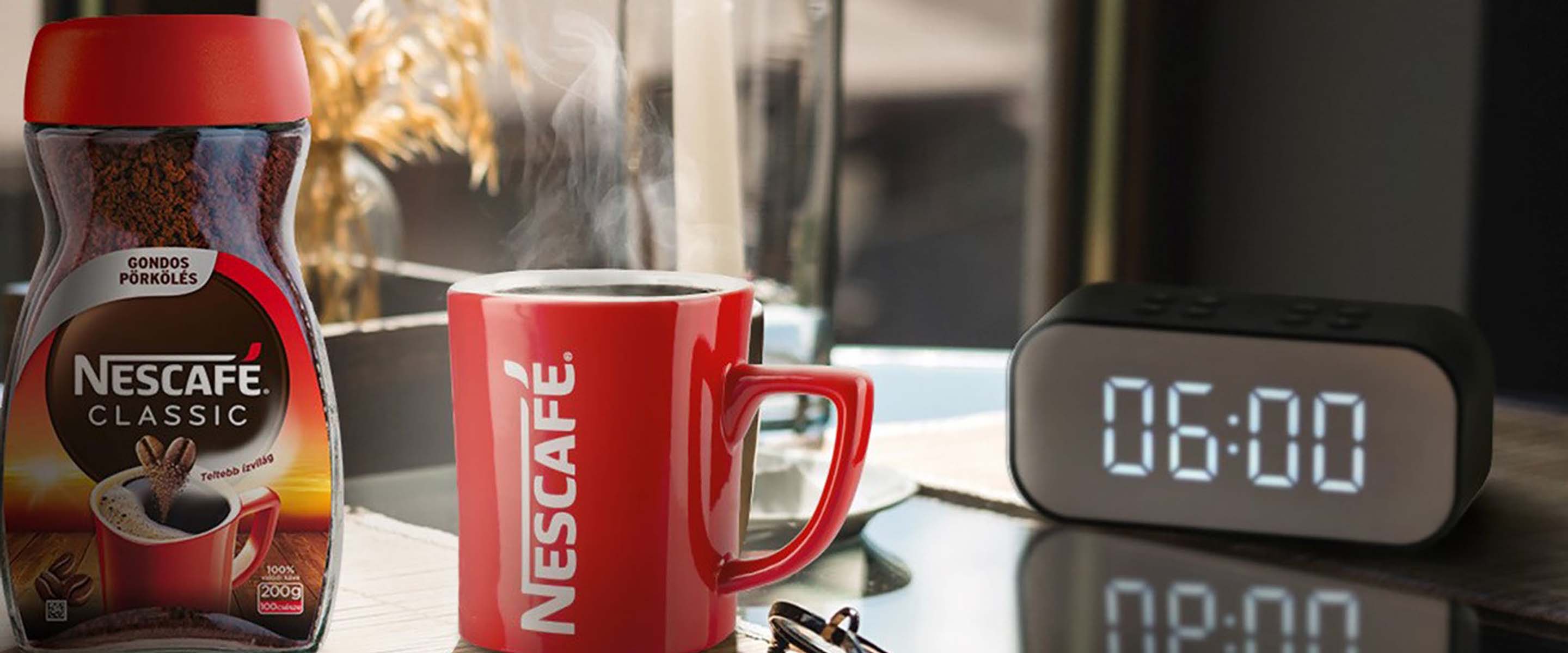 Két csésze finom krémes NESCAFÉ Classic egy asztalon, ébresztő órával