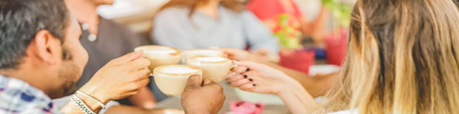 Four people celebrating with a coffee each