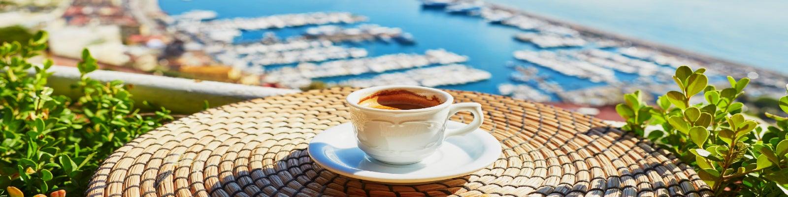 A cup of Italian coffee on a table overlooking a marina