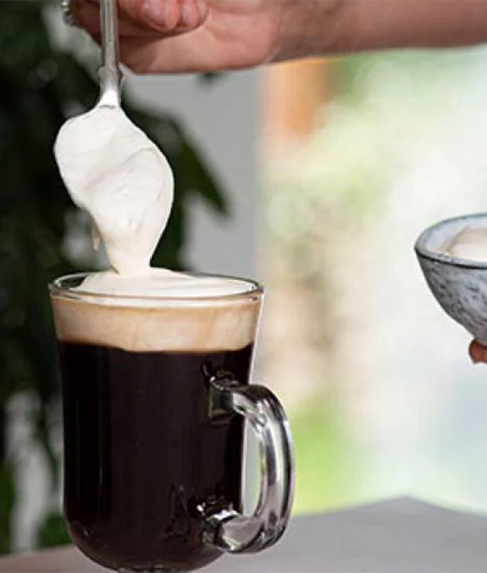 Pour into coffee glasses, top with cream and serve.