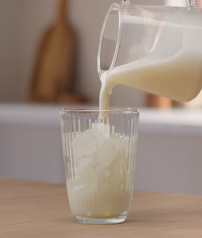 melk in glas met ijs gieten