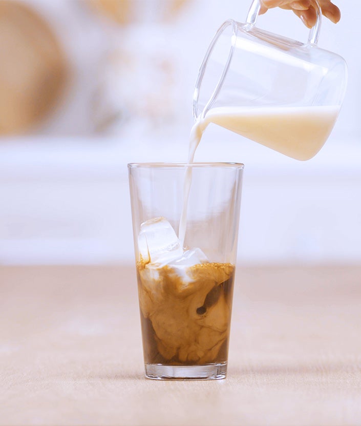 melk in espresso glas gieten
