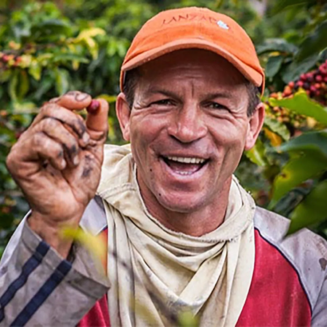 Smiling man holding coffee bean