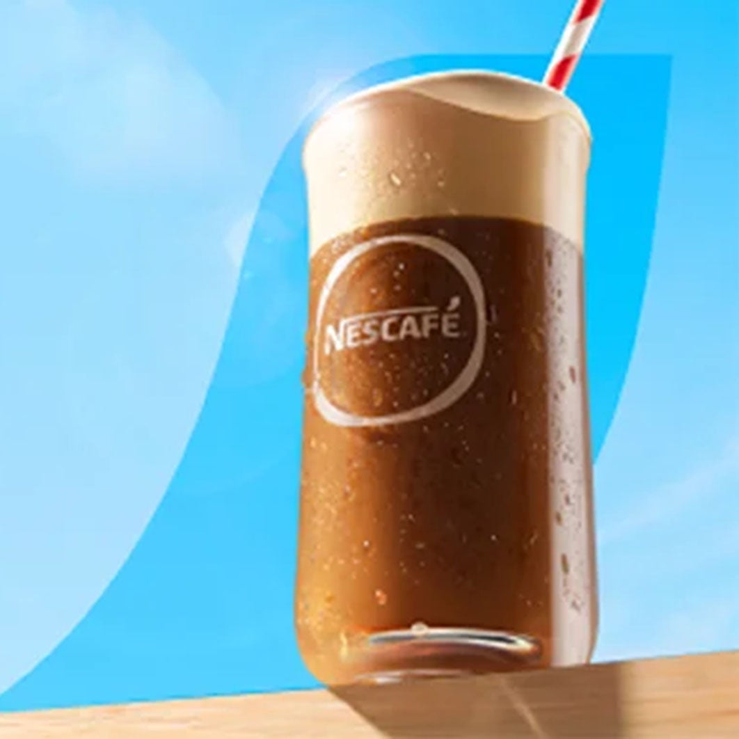 Szklanka NESCAFÉ Frappé na stole.