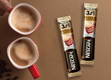 Czerwony kubek nescafe z saszetkami