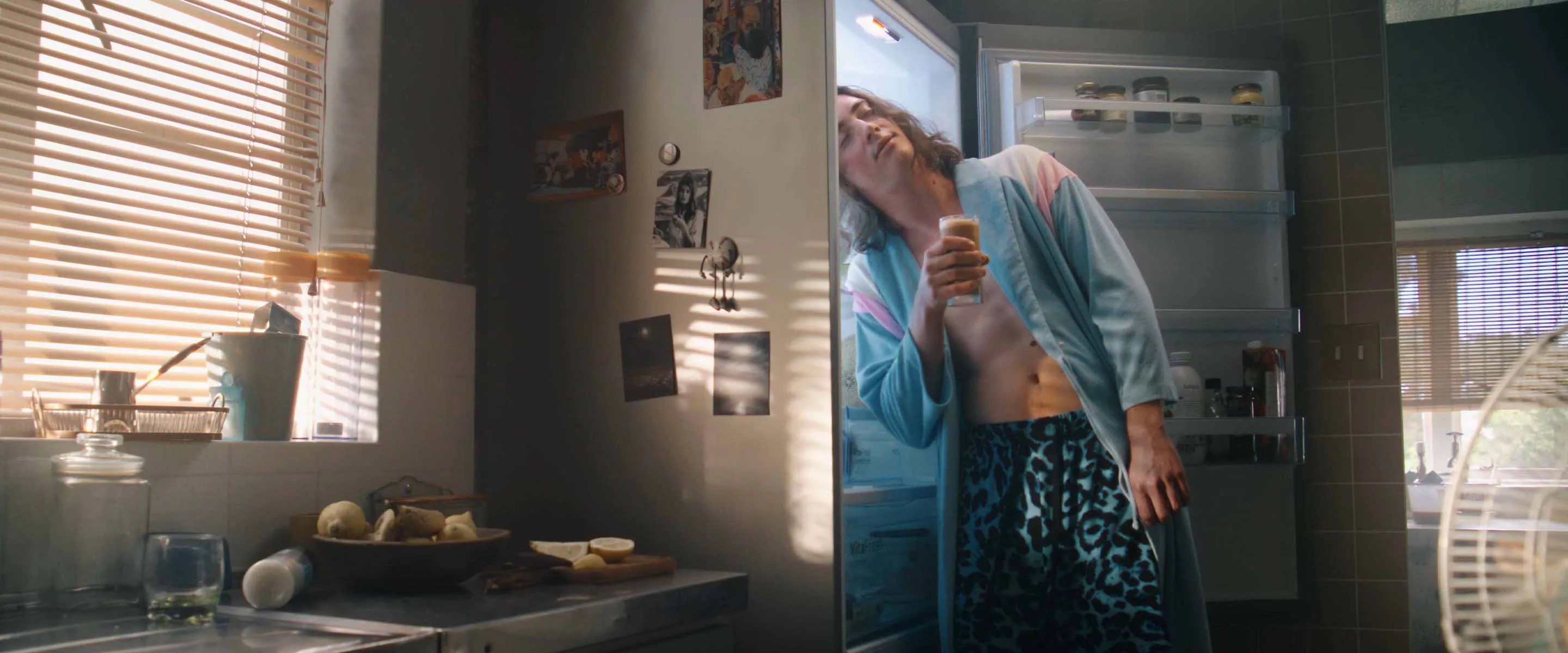 osoba pijąca kawę przy lodówce