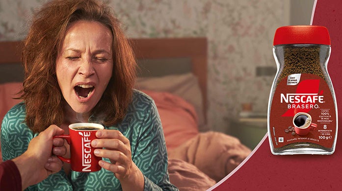 femeie trezindu-se cu o ceasca de nescafe brasero