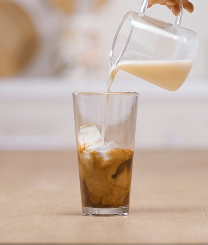 Sipanje mleka preko kafe i leda u šejkeru
