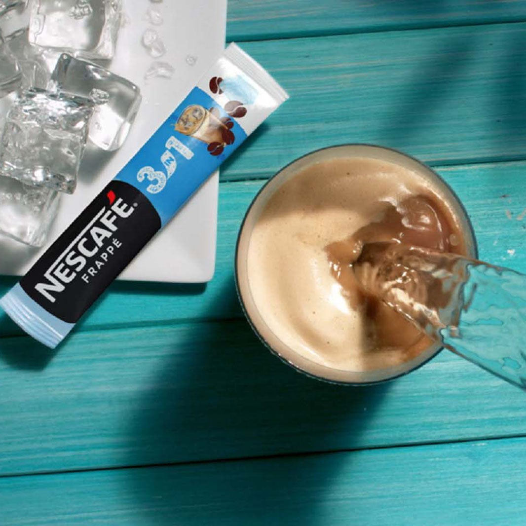Water pouring into a glass full of NESCAFÉ 3in1 ICE