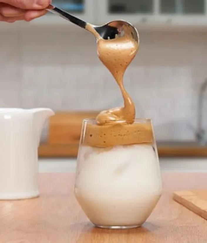 topping whipped coffee into cup