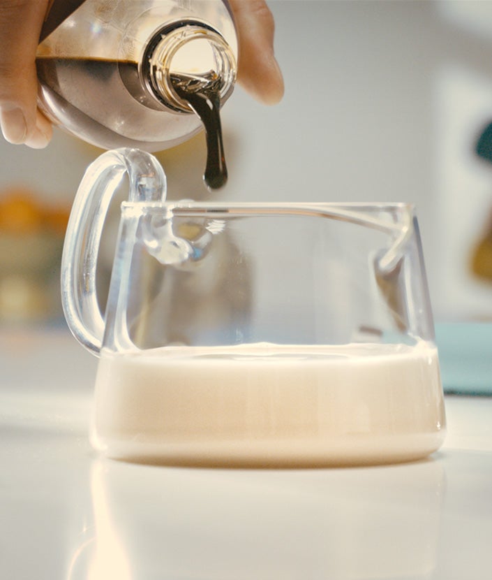 Adding NESCAFÉ® Espresso Concentrate in milk