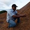 Coffee farmer inspecting organic compost used to improve soil health caraousel image