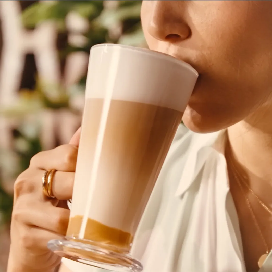 Glass of dulche de leche latte with NESCAFÉ® farmers origin coffee pods