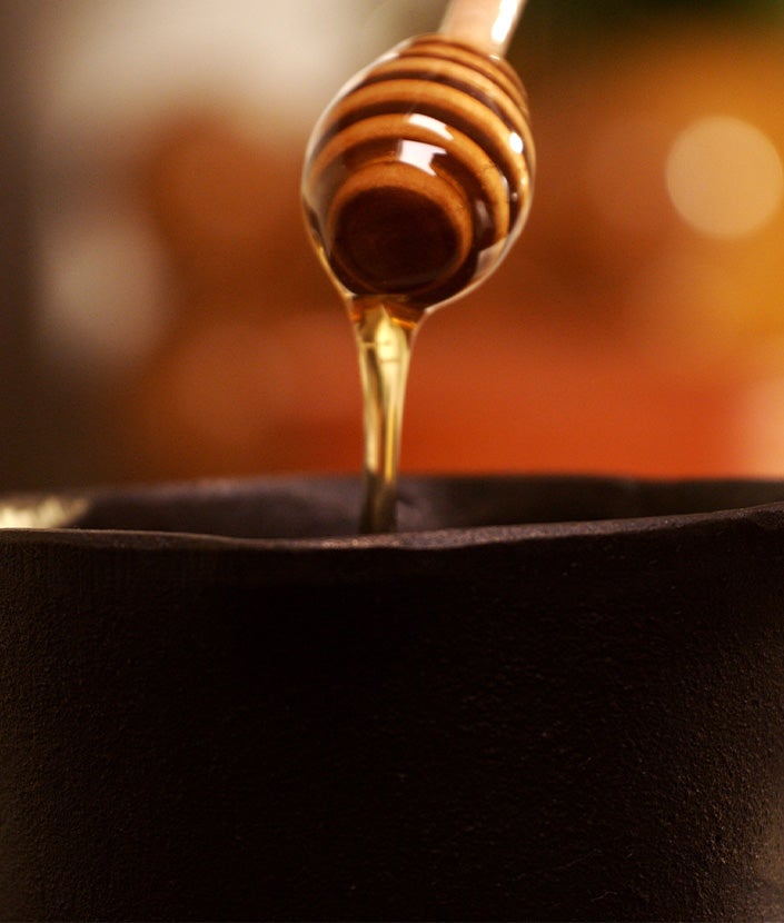 Adding honey in a pot