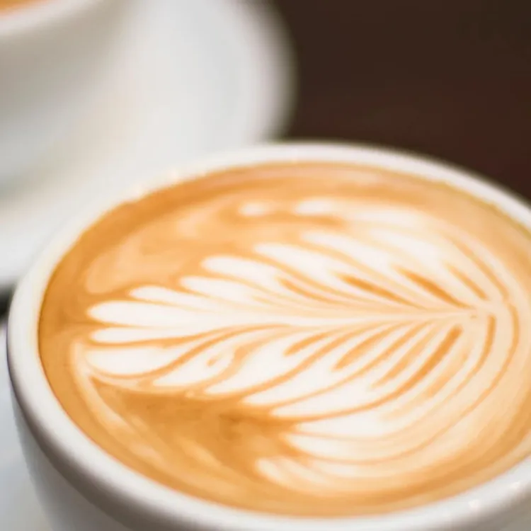 ภาพกาแฟลาเต้อาร์ตในแก้วสีขาว